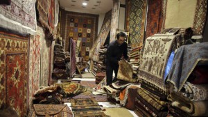 A seller arranges Iranian carpets at his shop in Dubai old market November 24, 2013. Iran's currency jumped more than 3 percent against the U.S. dollar on Sunday as news of a breakthrough deal to curb Tehran's nuclear program raised hopes that the economy would start recovering from international sanctions. Dubai's non-oil trade with Iran has shrunk by over a third in the past 18 months, totaling $2.9 billion in the first half of 2013, according to Dubai customs data. REUTERS/Mohammed Omar (UNITED ARAB EMIRATES - Tags: BUSINESS POLITICS)